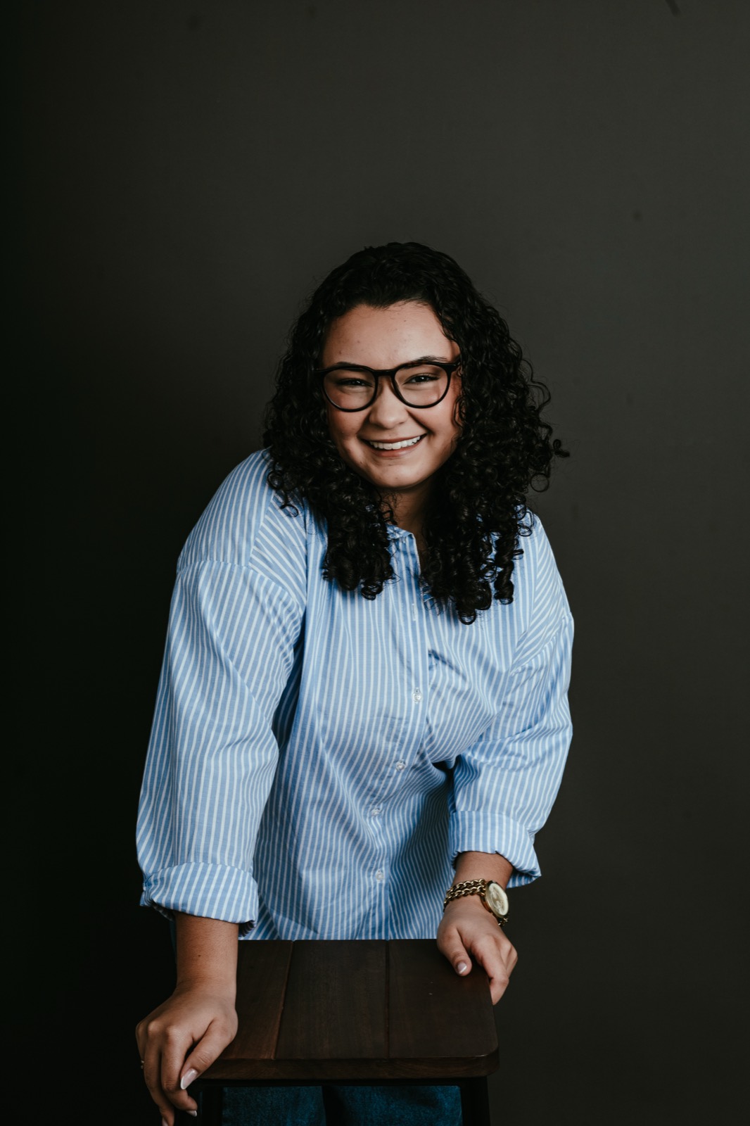 Retratada sentada, camisa azul-clara