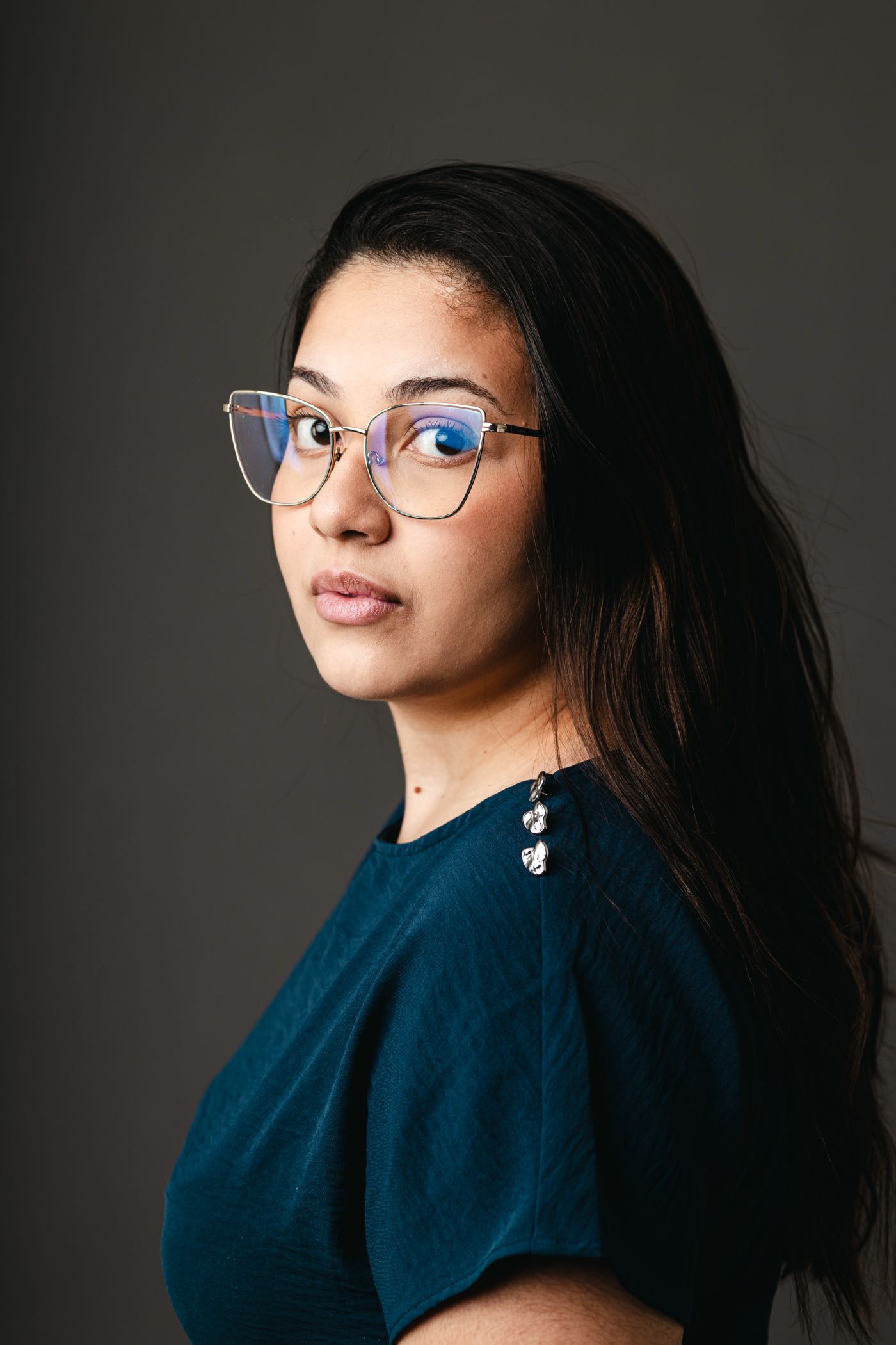 Elen em retrato fechado, de perfil, olhando para a câmera